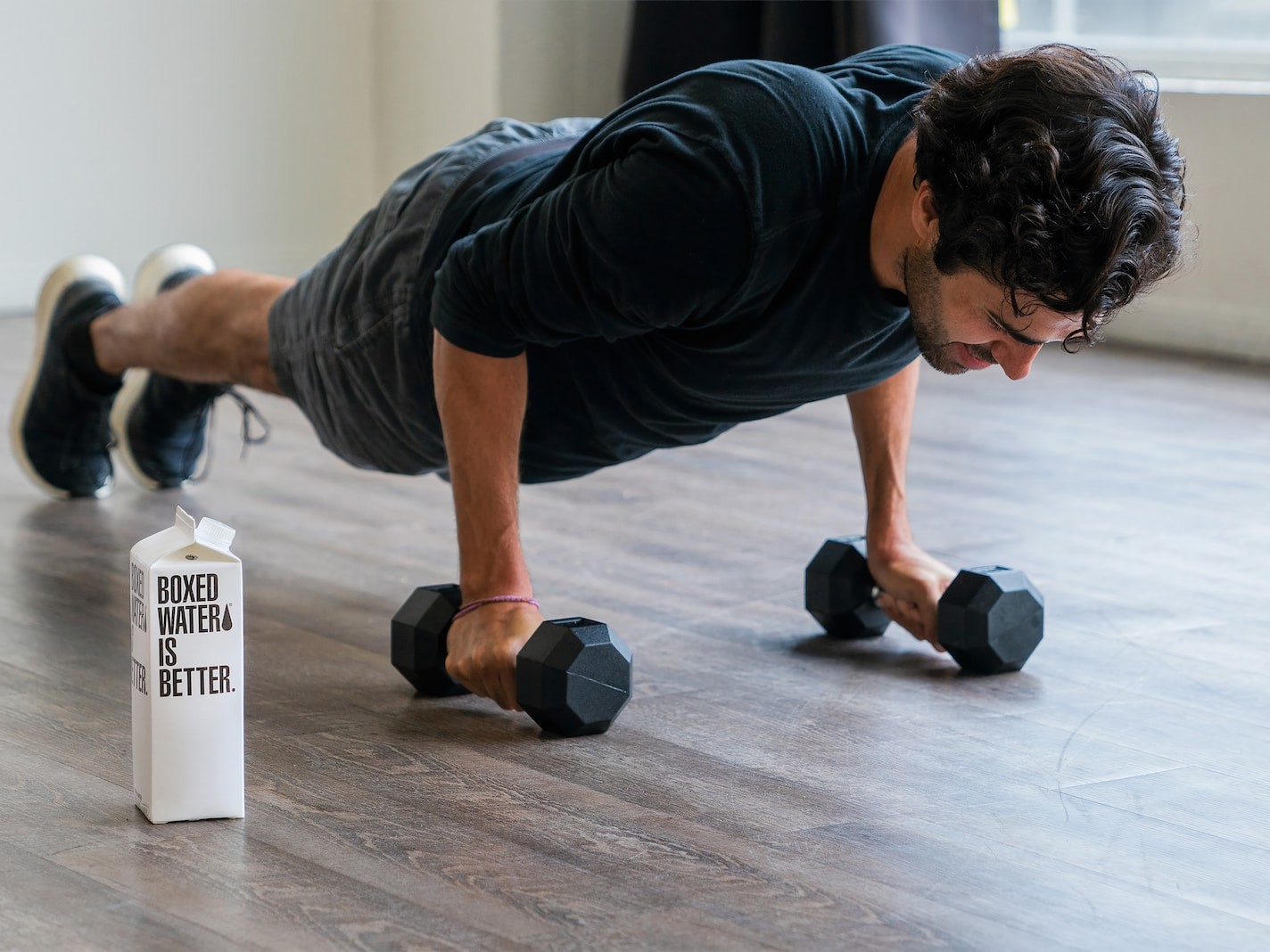 man in black t-shirt and black shorts doing push up